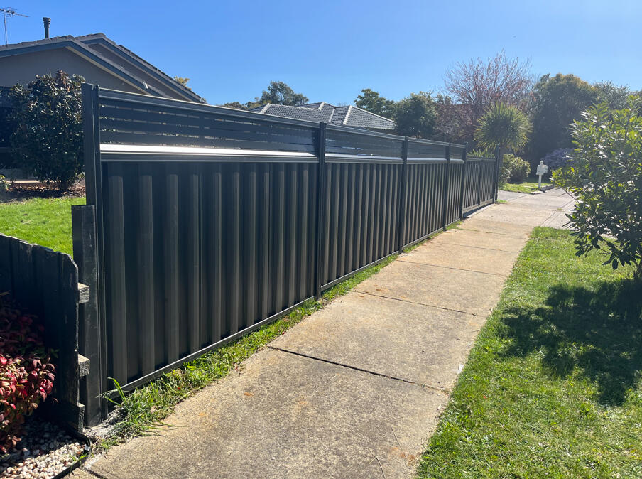 Monument Colorbond front fence with lattice extension and double driveway gates. 1.5m high Monument Colorbond front boundary fence with 300mm lattice extension and double driveway gates completed for added privacy and security in Narre Warren.