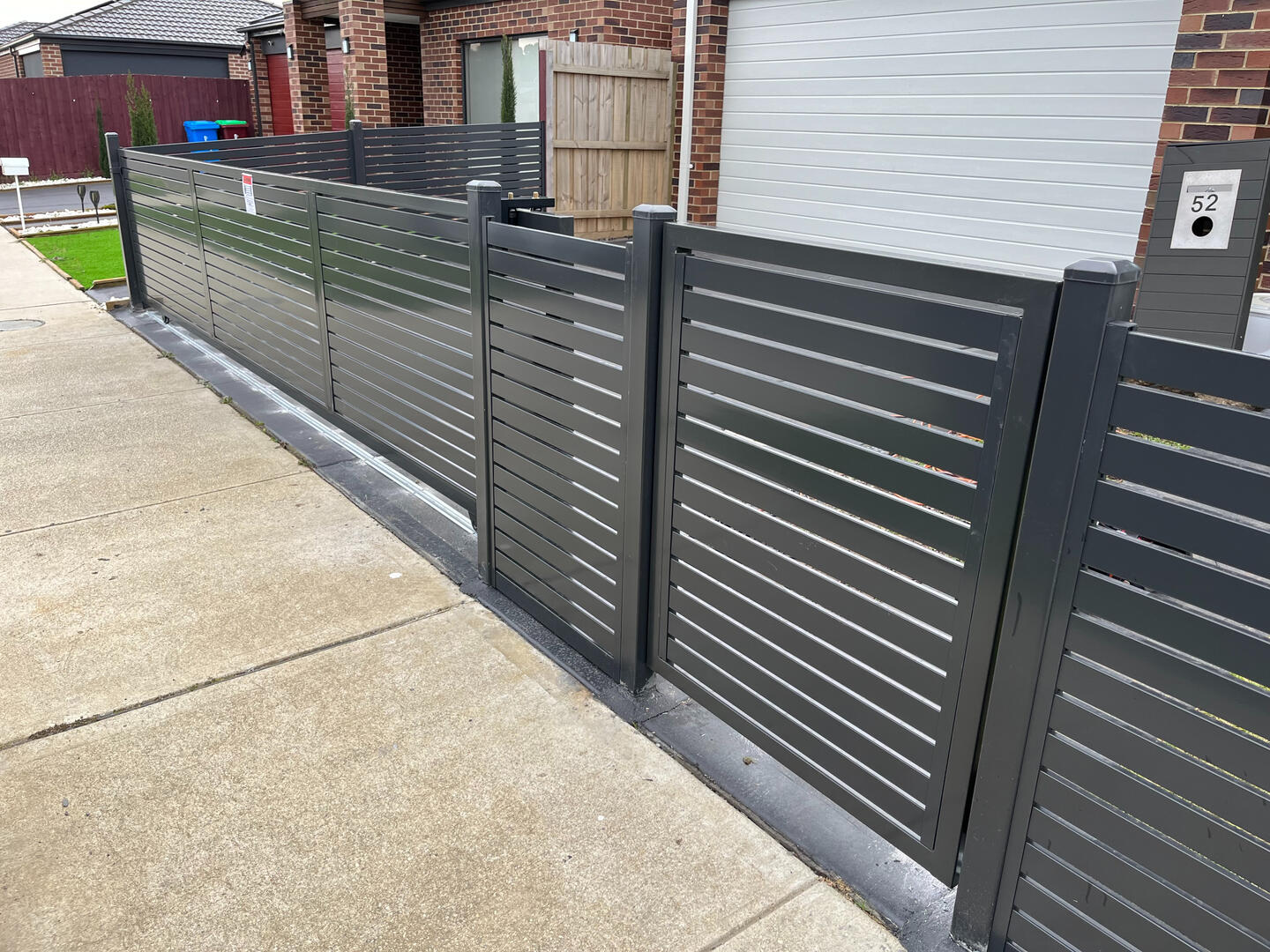 Custom Monument aluminium slat side access gate completed in Cranbourne featuring horizontal slats, 10mm gaps and a low-maintenance powder-coated finish for secure modern entry.