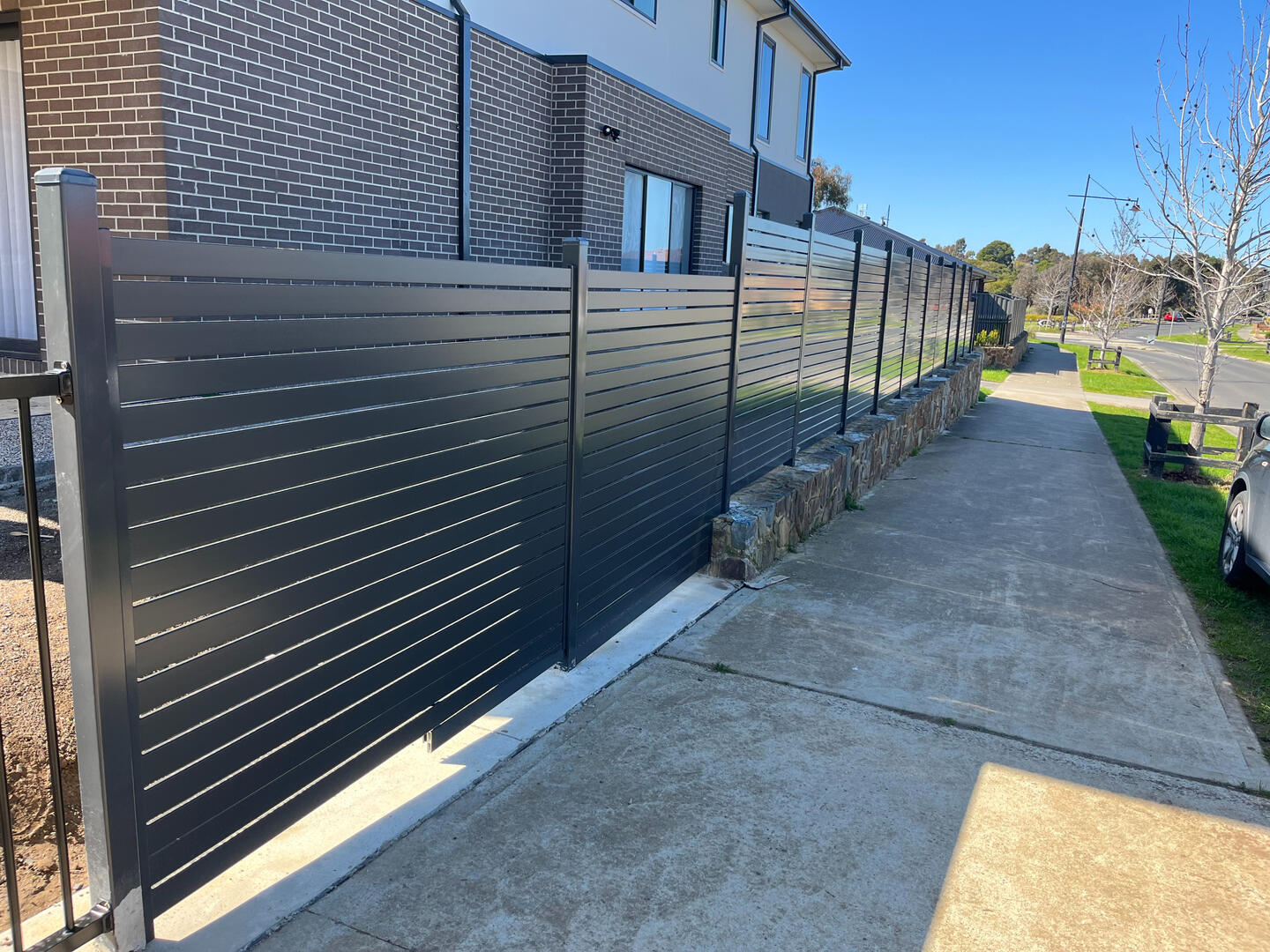 30m long aluminium slat front fence completed in Pakenham featuring 1.8m high privacy screening with 10mm gaps for a modern architectural look and improved street privacy.