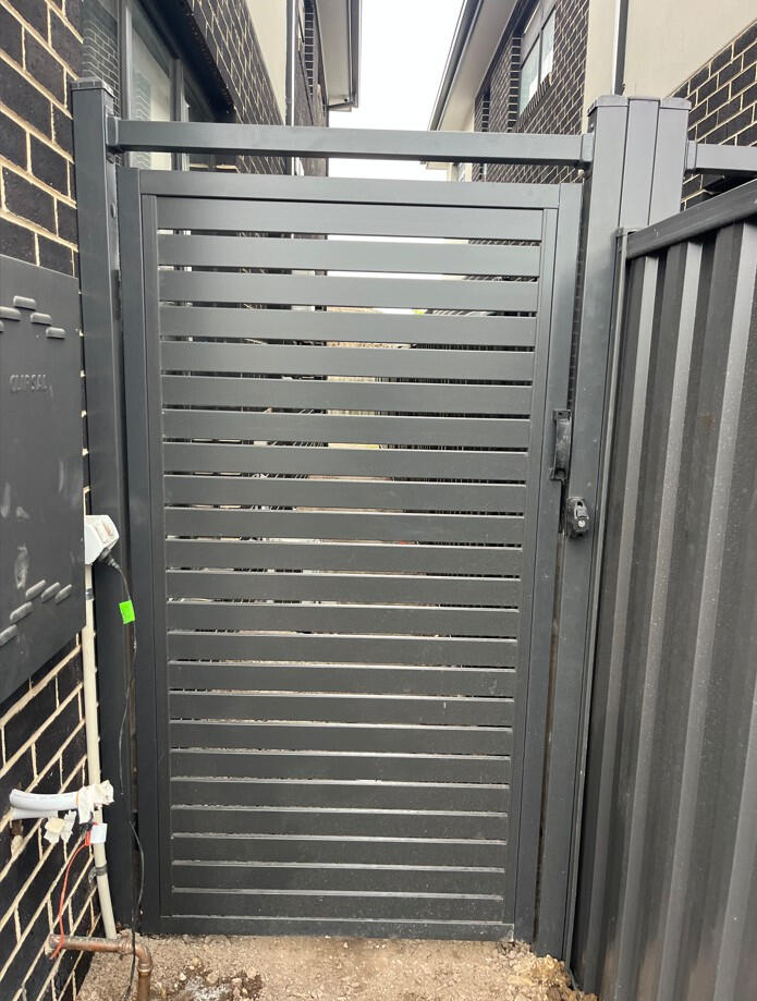 Modern aluminium slat gate with reinforced posts installed for a new architectural home in Dandenong. Custom aluminium slat pedestrian gate completed in Dandenong with reinforced steel posts for added strength, installed in one day to complement the architectural design of the new home.