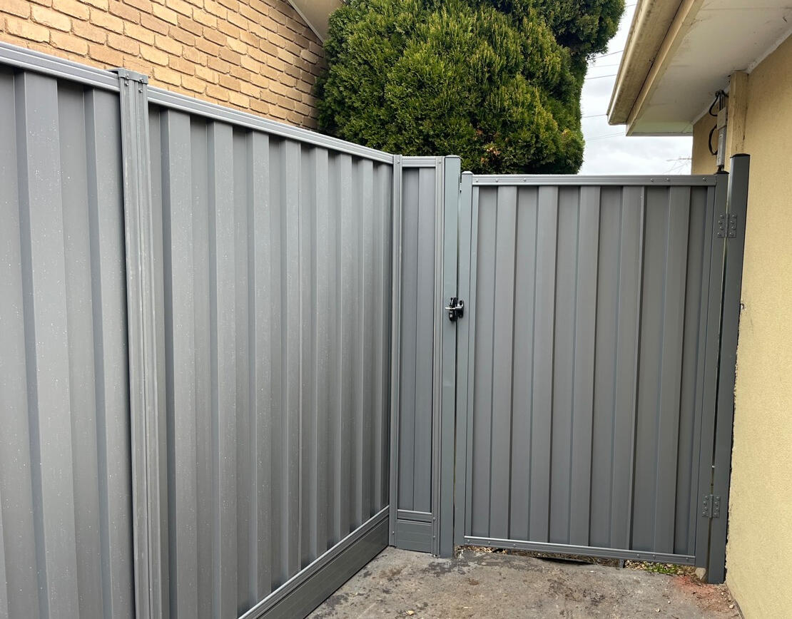 Basalt Colorbond side gate installed to match existing fencing and aluminium sleepers. Basalt Colorbond pedestrian side gate completed in Noble Park to match existing privacy fencing and aluminium sleepers for improved backyard access and security.