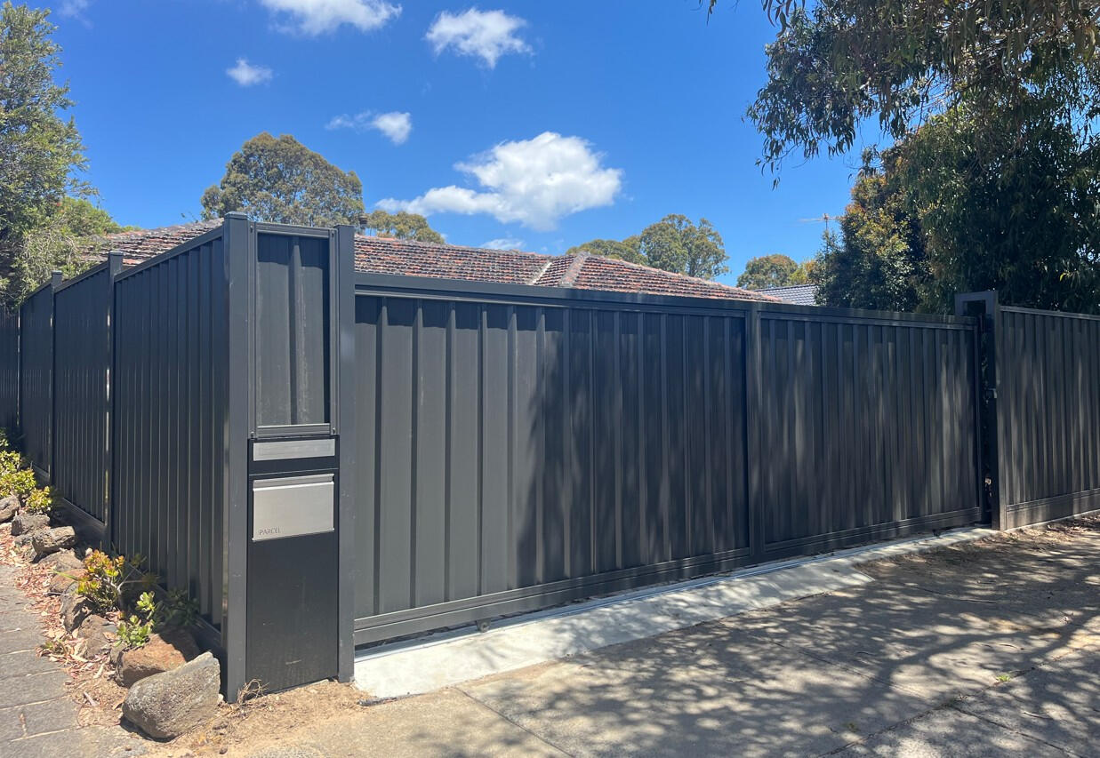 Monument Colorbond sliding gate with keypad access, parcel box and automatic motor system. 6m automated Colorbond driveway gate completed in Carrum Downs featuring remote controls, keypad entry, parcel box, safety sensors and motorised access system for enhanced residential security.