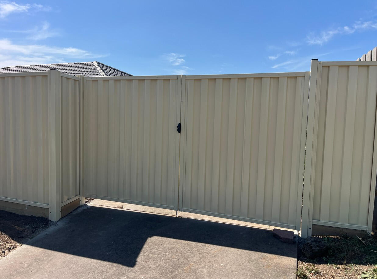 Cream Colorbond double swing gates replacing old timber driveway gates in Cranbourne North. Custom cream Colorbond double swing driveway gates completed in Cranbourne North as a replacement for old timber gates, improving both security and the overall appearance of the home.