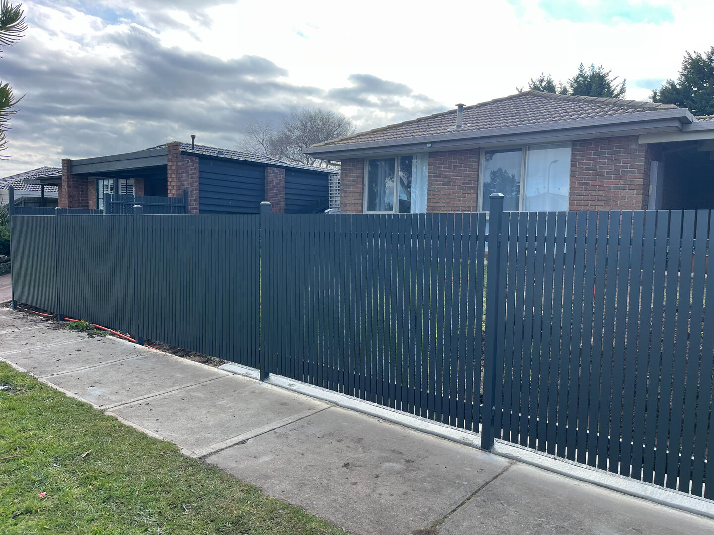 Custom Monument aluminium slat front boundary fence completed in Cranbourne North featuring welded vertical slats for improved privacy, pet security and modern street appeal.