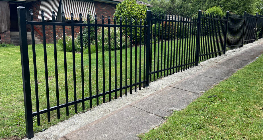 Black spear-top security fencing with stepped panels installed at a property in Drouin. 1.5m high black spear-top security fencing completed in Drouin featuring stepped panel design for a sloping front boundary and improved residential security.